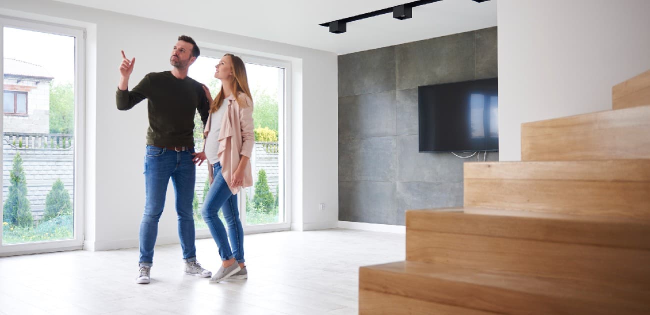 A man and a woman look around the inside of a new home.