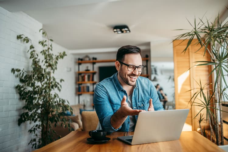 Cheerful man making call on a laptop computer