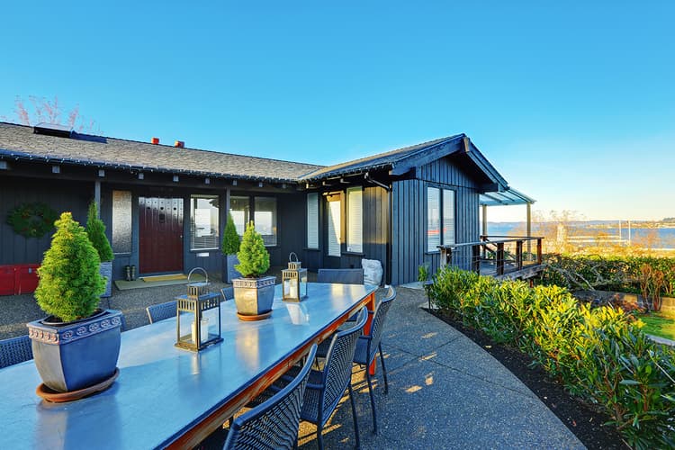 Waterfront house with table and chairs on patio